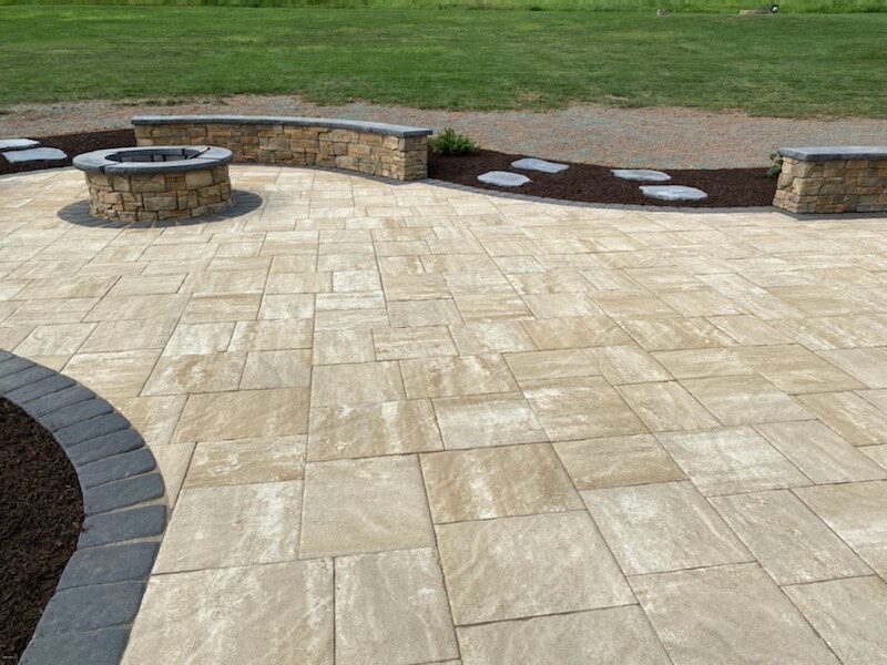 A hardscaped stone walkway with stone walls and mulch