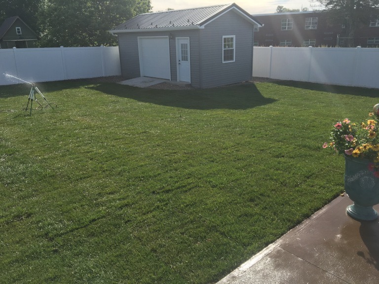 A sprinkler system watering the back yard